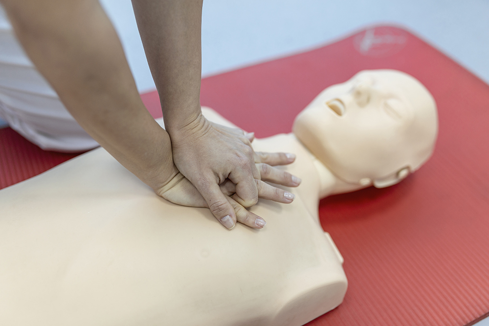 CPR class with instructors talking and demonstrating firt aid, compressions ans reanimation procedure. Cpr dummy