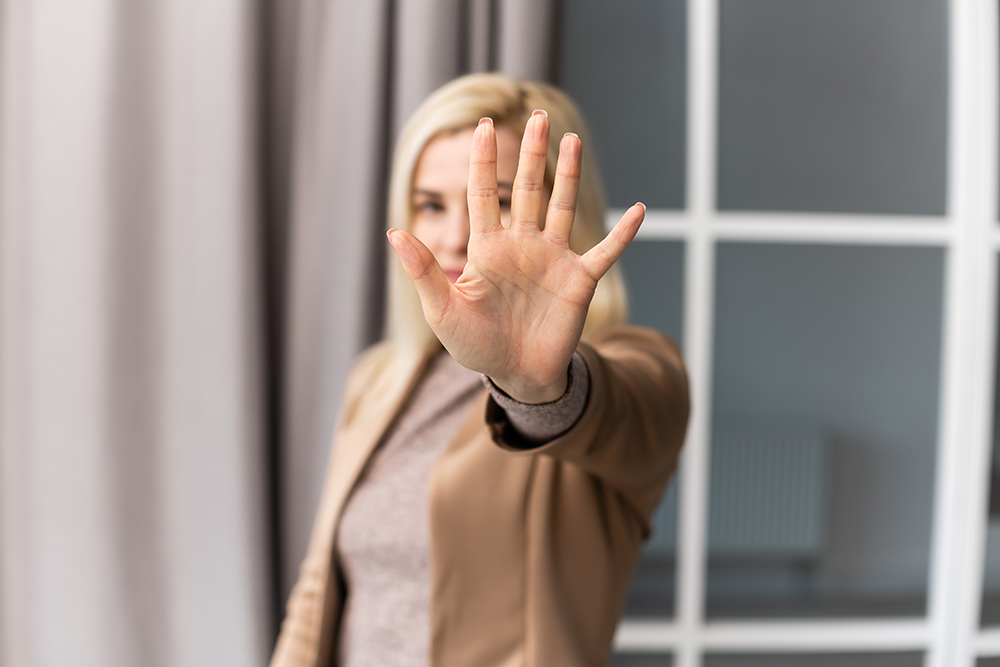 bright picture of young woman making stop gesture.